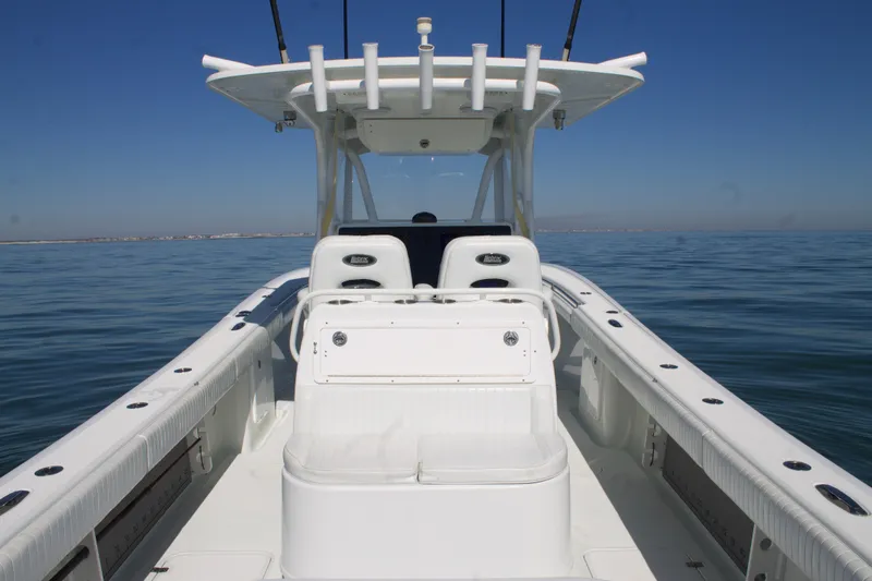  Yacht Photos Pics 2014 Yellowfin 32 Offshore boat on calm sea, featuring spacious deck and seating.