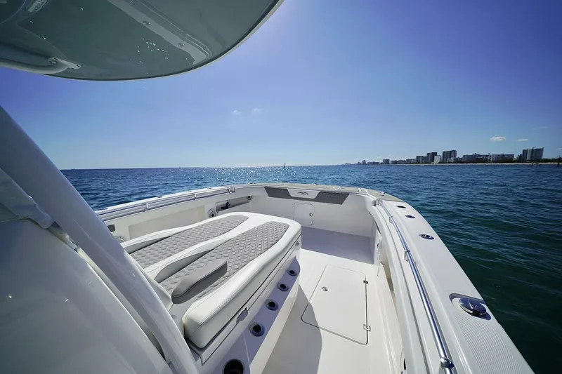 Little Lady Yacht Photos Pics 2024 Invincible 35 Catamaran cruising on open sea with city skyline in background.