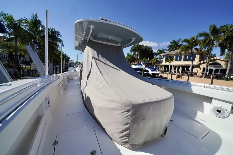 Little Lady Yacht Photos Pics 2024 Invincible 35 Catamaran with covered console, docked near palm trees and waterfront homes.