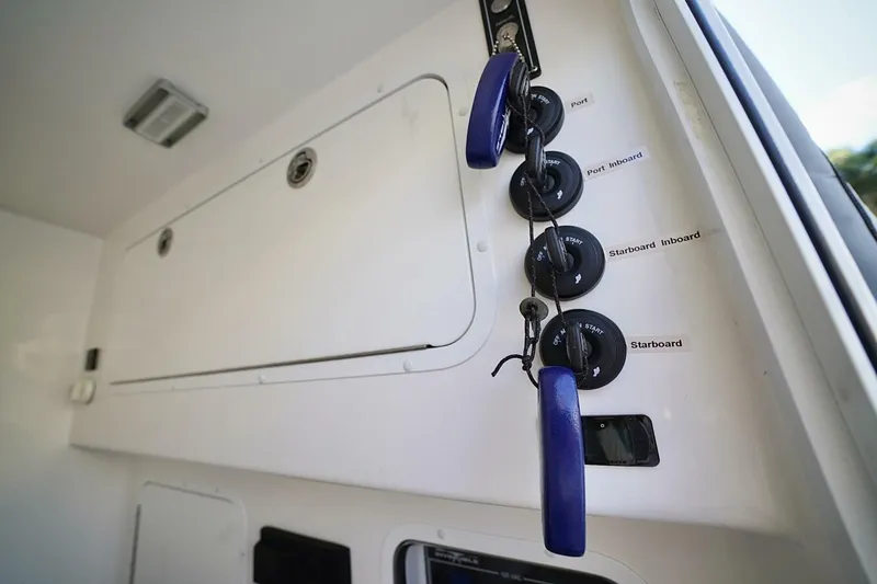Little Lady Yacht Photos Pics 2024 Invincible 35 Catamaran control panel with labeled ignition switches and keys.