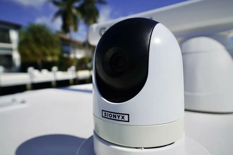 Little Lady Yacht Photos Pics SIONYX camera on 2024 Invincible 35 Catamaran, with blurred background of palm trees and water.