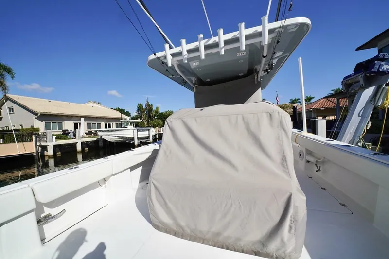 Little Lady Yacht Photos Pics 2024 Invincible 35 Catamaran boat deck with covered seating, docked near waterfront homes.