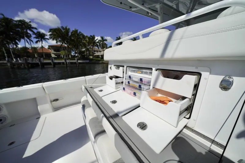 Little Lady Yacht Photos Pics 2024 Invincible 35 Catamaran with open storage compartments, dockside view, and palm trees in the background.