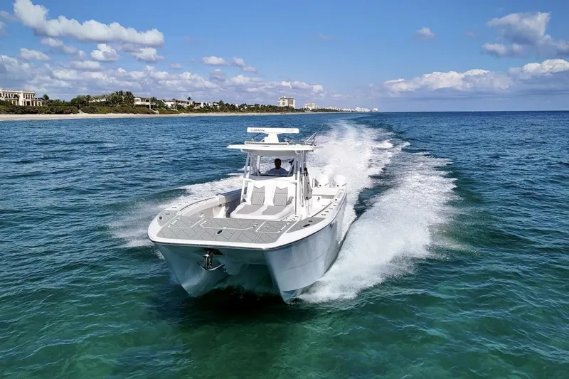 Little Lady Yacht Photos Pics 2024 Invincible 35 Catamaran cruising on clear blue ocean waters.