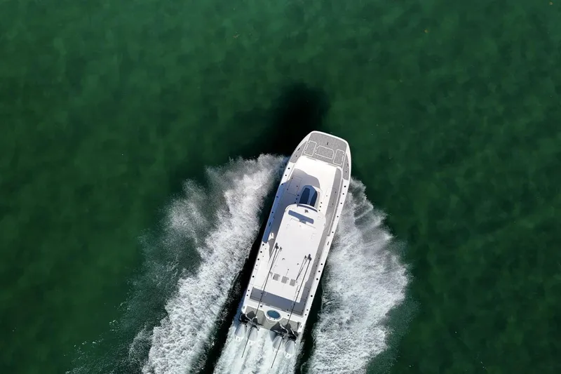 Little Lady Yacht Photos Pics Aerial view of 2024 Invincible 35 Catamaran cruising on clear green water.