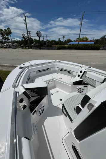 252 - 457 Yacht Photos Pics 2025 Blackfin 252 CC boat interior with seating and speakers under a clear sky.