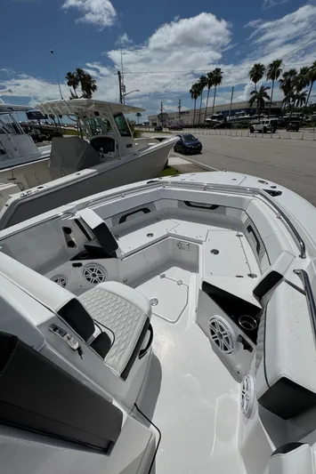 252 - 457 Yacht Photos Pics 2025 Blackfin 252 CC boat interior with seating, speakers, and cup holders under a sunny sky.