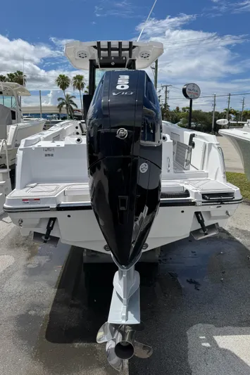 252 - 457 Yacht Photos Pics 2025 Blackfin 252 CC boat with powerful outboard motor, docked under clear skies.