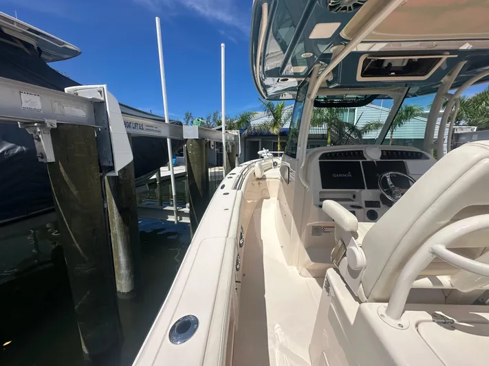 Sea-keeper/gen/ac/trolling Motor Yacht Photos Pics 2021 Grady-White Canyon 336 boat docked, featuring helm and seating area under clear blue sky.