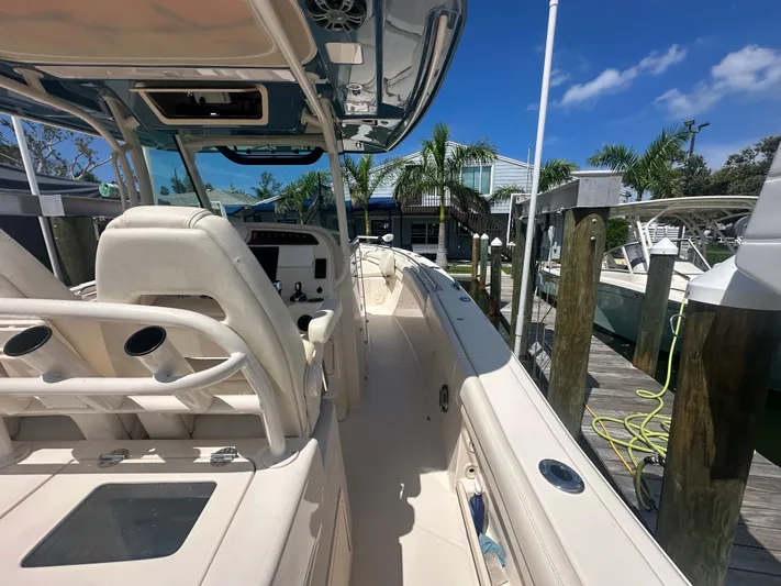 Sea-keeper/gen/ac/trolling Motor Yacht Photos Pics 2021 Grady-White Canyon 336 boat docked, showcasing helm and seating area under clear blue sky.