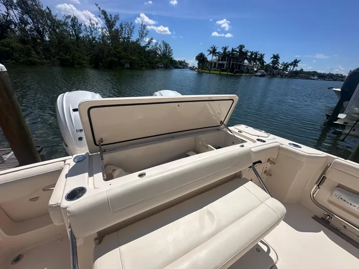 Sea-keeper/gen/ac/trolling Motor Yacht Photos Pics 2021 Grady-White Canyon 336 boat with open storage, docked by a scenic waterfront.