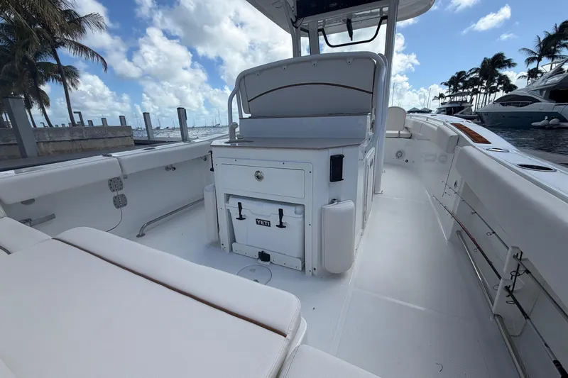  Yacht Photos Pics 2022 Sea Hunt Ultra 275 SE boat interior with seating and storage, docked by palm trees.