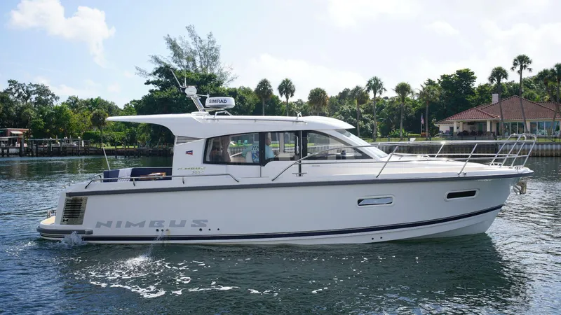In-stock 2024 Nimbus 305 Coupé #393 Yacht Photos Pics 2024 Nimbus 305 Coupe #393 cruising on a serene waterway.