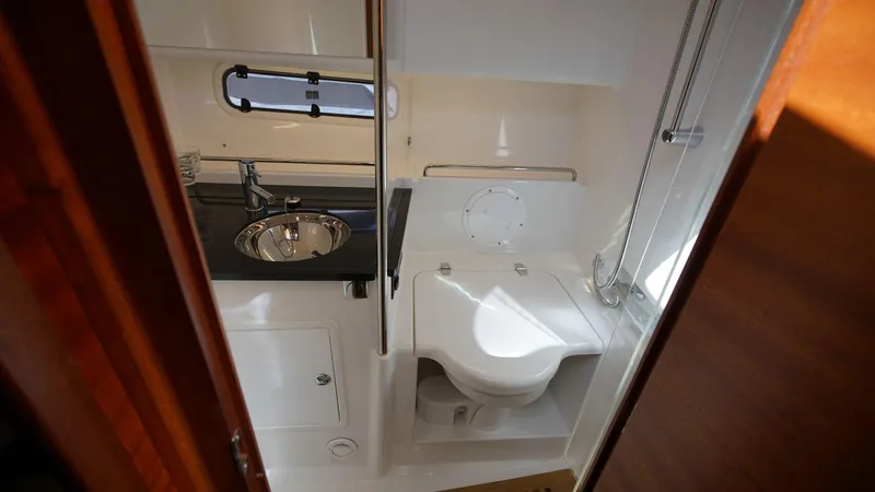In-stock 2024 Nimbus 305 Coupé #393 Yacht Photos Pics Compact bathroom in 2024 Nimbus 305 Coupe #393 with sink and toilet.