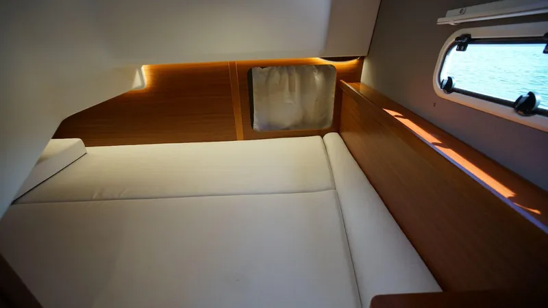 In-stock 2024 Nimbus 305 Coupé #393 Yacht Photos Pics Interior cabin of 2024 Nimbus 305 Coupe #393 with a cozy bed and window view.