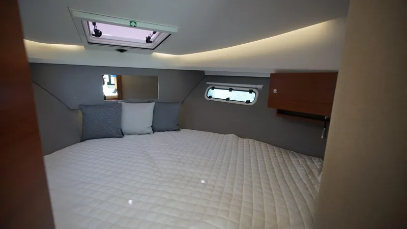 In-stock 2024 Nimbus 305 Coupé #393 Yacht Photos Pics 2024 Nimbus 305 Coupe #393 cabin interior with bed and skylight.