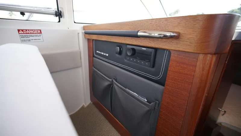 In-stock 2024 Nimbus 305 Coupé #393 Yacht Photos Pics Interior detail of 2024 Nimbus 305 Coupe #393, featuring wooden paneling and storage pockets.
