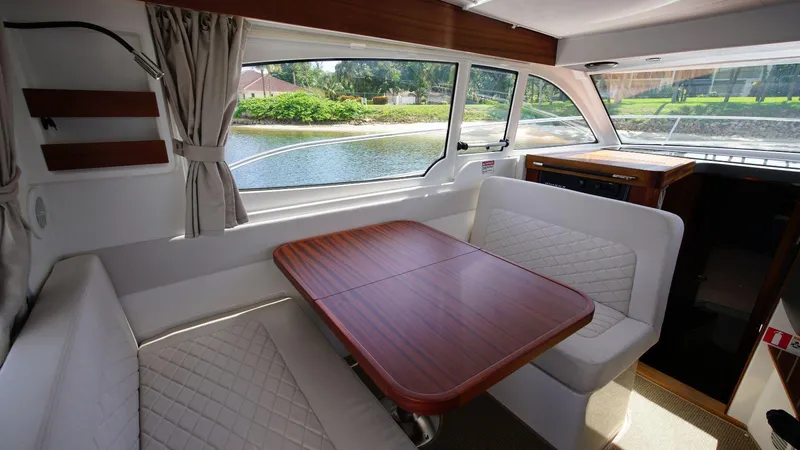 In-stock 2024 Nimbus 305 Coupé #393 Yacht Photos Pics Interior of 2024 Nimbus 305 Coupe #393 with dining area and river view.