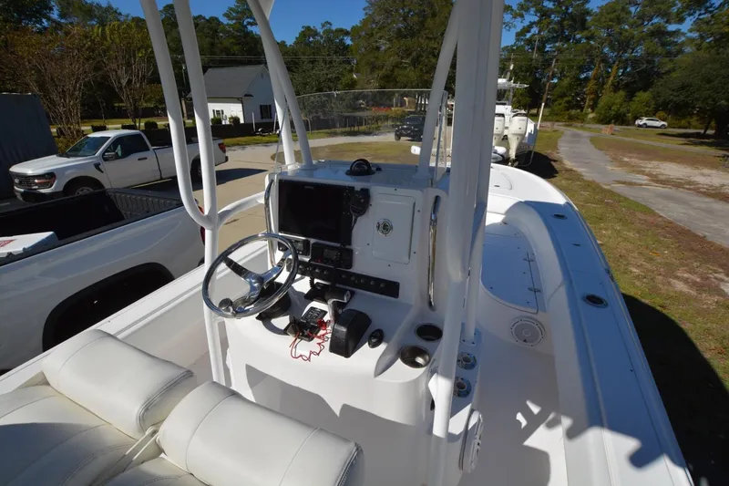 Hot Hooks II Yacht Photos Pics 2013 Contender 25 Bay boat interior with steering console and seating, parked outdoors.