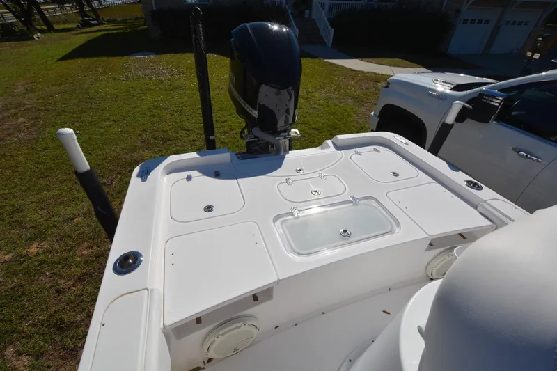 Hot Hooks II Yacht Photos Pics 2013 Contender 25 Bay boat with motor, parked on grass beside a white truck.