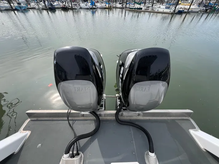  Yacht Photos Pics Twin outboard motors on a 2021 Velocity LC3311 boat, docked in a marina.