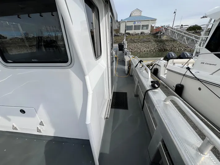  Yacht Photos Pics 2021 Velocity LC3311 boat docked, showing side deck and marina background.