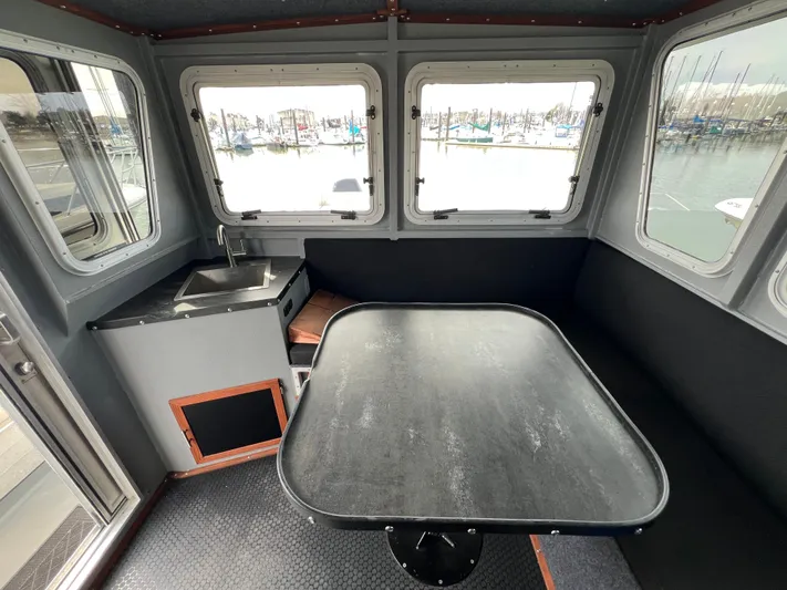  Yacht Photos Pics Interior of 2021 Velocity LC3311 boat with table and sink, overlooking marina.