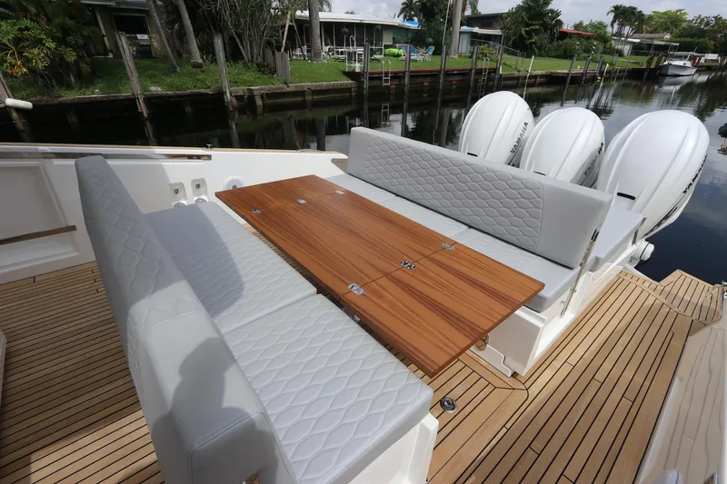  Yacht Photos Pics 2024 Astondoa 377 Coupe Outboard with elegant seating and wooden table on deck.