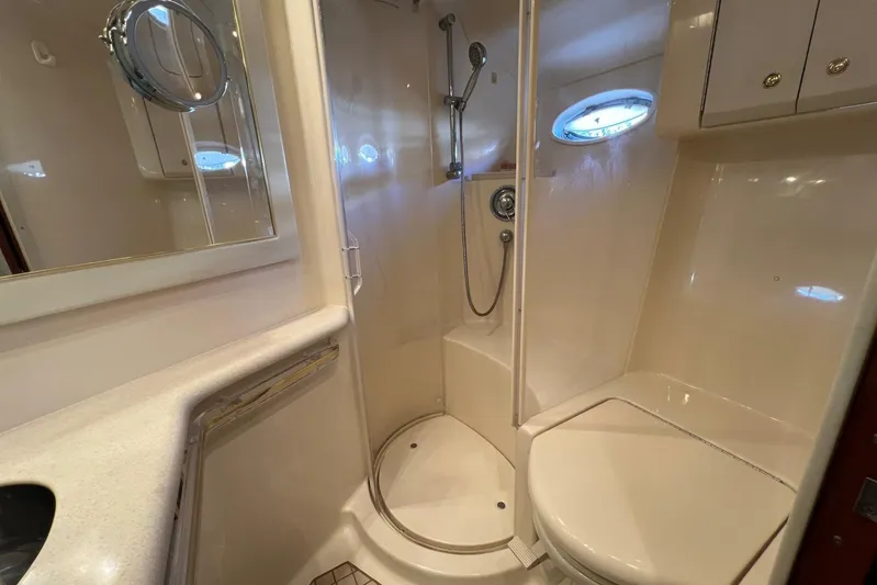  Yacht Photos Pics Bathroom interior of 1998 Sea Ray 540 Sundancer yacht, featuring shower and porthole window.