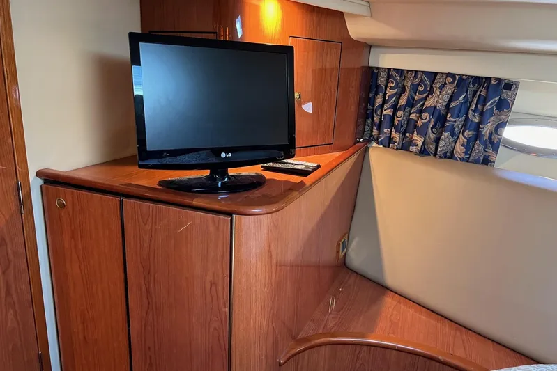  Yacht Photos Pics 1998 Sea Ray 540 Sundancer interior with TV, wooden cabinetry, and patterned curtains.