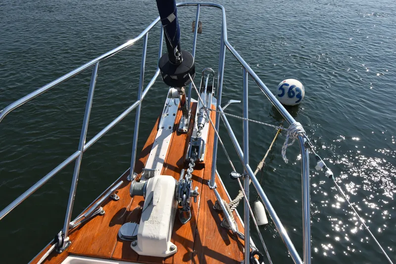Chinook Yacht Photos Pics Bow of 2004 Island Packet 485 sailboat with mooring buoy on calm water.