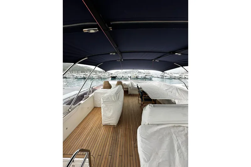  Yacht Photos Pics Covered deck of a 2014 Princess 72 yacht, featuring wooden flooring and marina view.