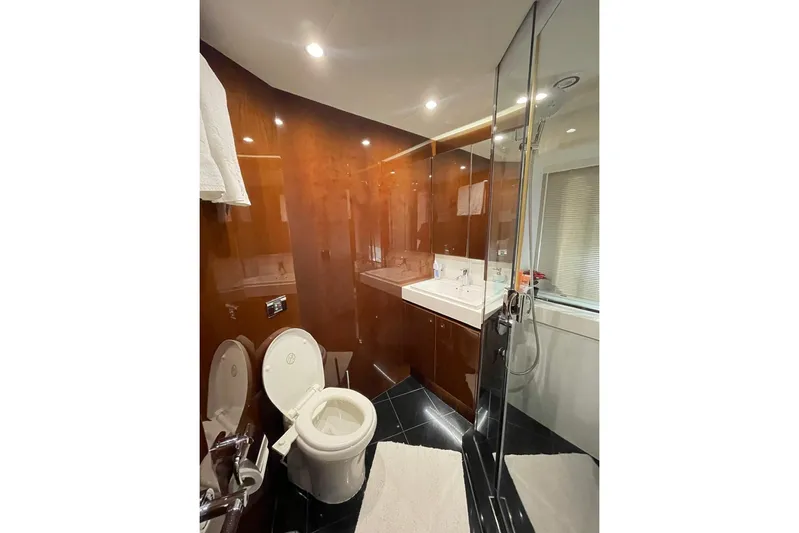  Yacht Photos Pics Luxurious bathroom in 2014 Princess 72 yacht with modern fixtures and elegant wood paneling.