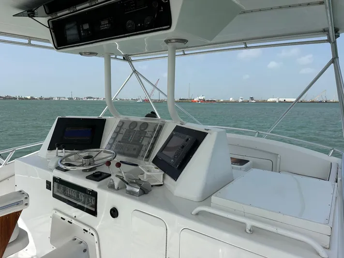  Yacht Photos Pics 1990 Bertram 50 Convertible yacht helm with modern navigation equipment on open water.