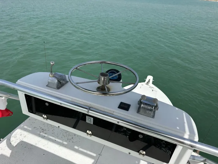  Yacht Photos Pics Bertram 50 Convertible 1990 boat helm with steering wheel and controls on open water.