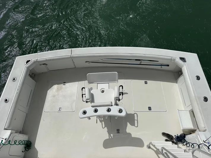  Yacht Photos Pics 1990 Bertram 50 Convertible boat deck with fishing chair, surrounded by water.