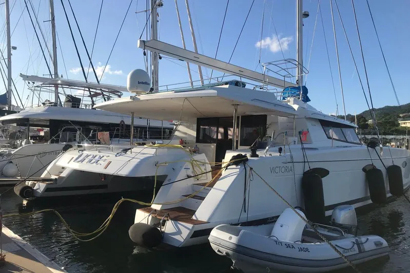 Sea Jade Yacht Photos Pics 2014 FONTAINE PAJOT 63 yacht docked at marina with inflatable boat nearby.