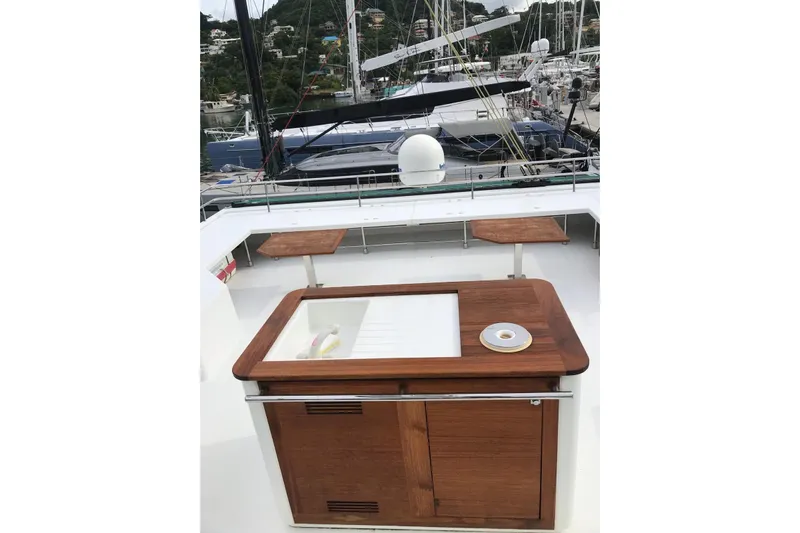 Sea Jade Yacht Photos Pics Deck view of 2014 FONTAINE PAJOT 63 yacht with wooden cabinetry and marina backdrop.