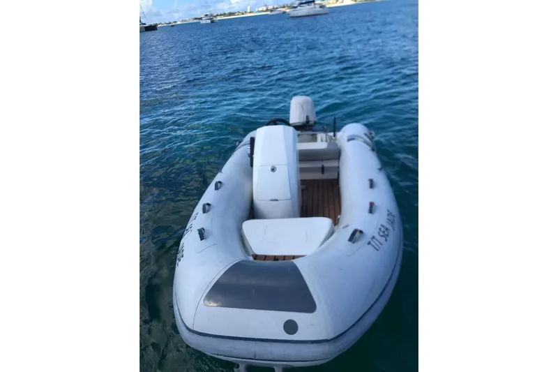 Sea Jade Yacht Photos Pics Inflatable boat on water, 2014 FONTAINE PAJOT 63 model, with distant yachts in background.