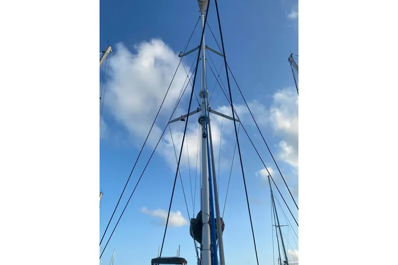 Sea Jade Yacht Photos Pics Mast of 2014 FONTAINE PAJOT 63 sailboat against blue sky with clouds.