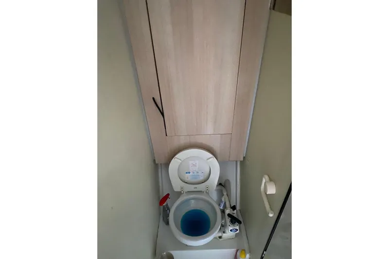 Sea Jade Yacht Photos Pics Toilet area in 2014 FONTAINE PAJOT 63 yacht, featuring blue water and wooden cabinet.