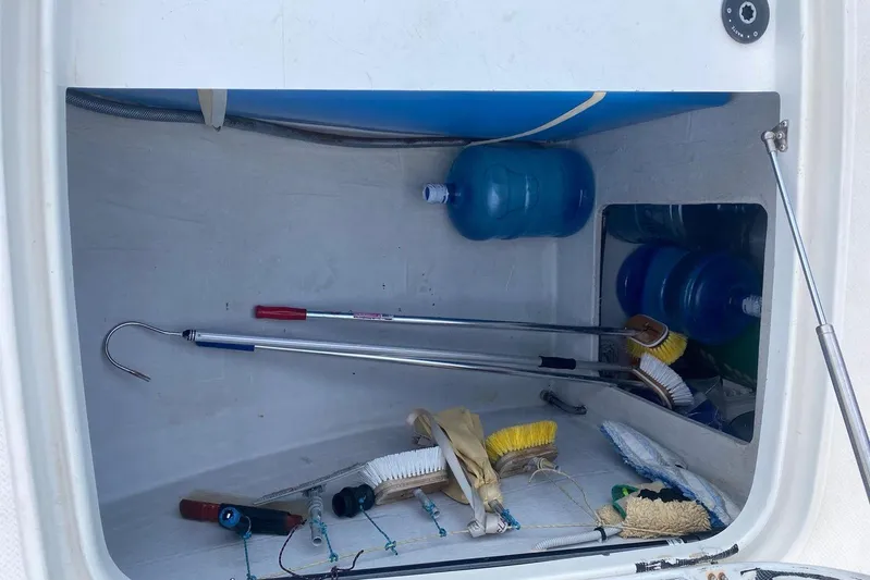 Sea Jade Yacht Photos Pics Storage compartment on a 2014 FONTAINE PAJOT 63 with cleaning tools and water bottles.