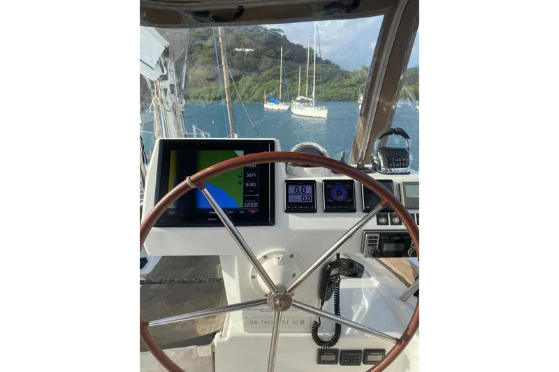 Sea Jade Yacht Photos Pics Helm of 2014 FONTAINE PAJOT 63 yacht with navigation screens and steering wheel.