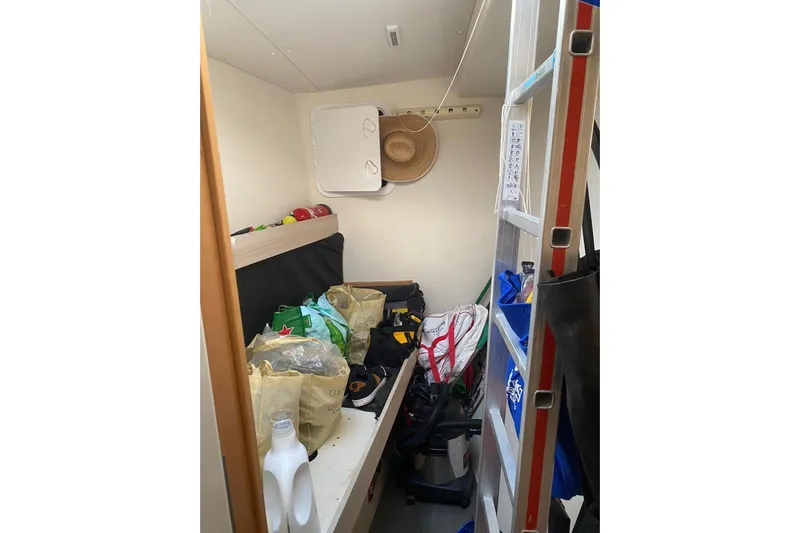 Sea Jade Yacht Photos Pics Small storage room on a 2014 FONTAINE PAJOT 63 yacht, cluttered with bags and a ladder.