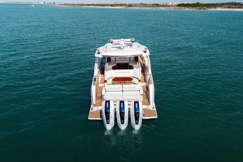 Phoenix Yacht Photos Pics 2023 Tiara 48 yacht with triple outboard engines on open water.