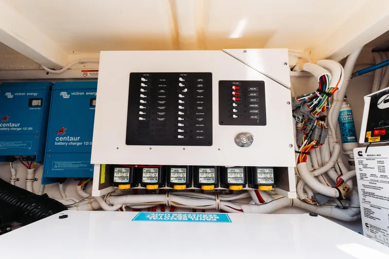Phoenix Yacht Photos Pics Electrical panel and battery chargers in a 2023 Tiara 48 yacht engine room.