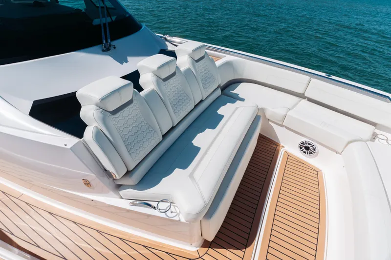 Phoenix Yacht Photos Pics Luxurious seating on 2023 Tiara 48 yacht, featuring elegant white upholstery and teak flooring.