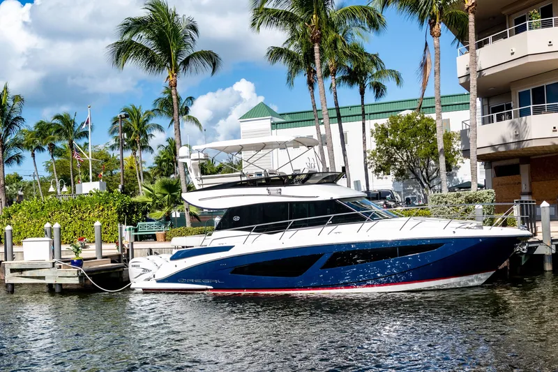 Syren Yacht Photos Pics 2022 Regal 42 FXO yacht docked by palm trees and buildings.