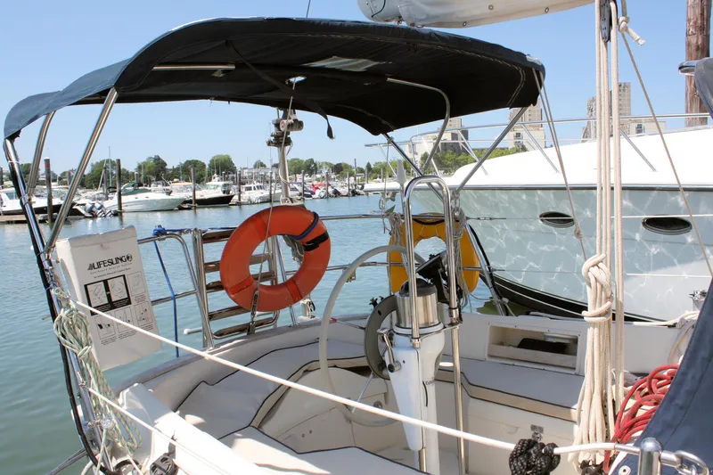 Tigerlily Yacht Photos Pics 2004 Pacific Seacraft 31 sailboat with lifebuoy and canopy in a marina setting.