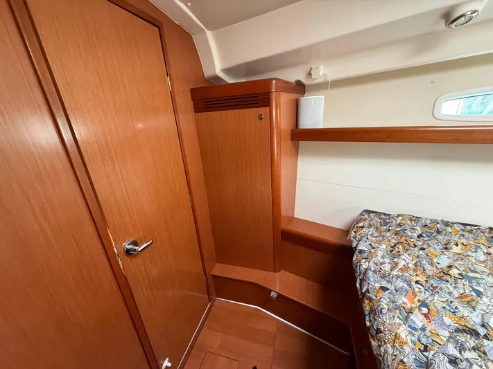 Deep Unreal Yacht Photos Pics Interior cabin of 2008 Beneteau Oceanis 40 sailboat with wooden finish and patterned bedding.